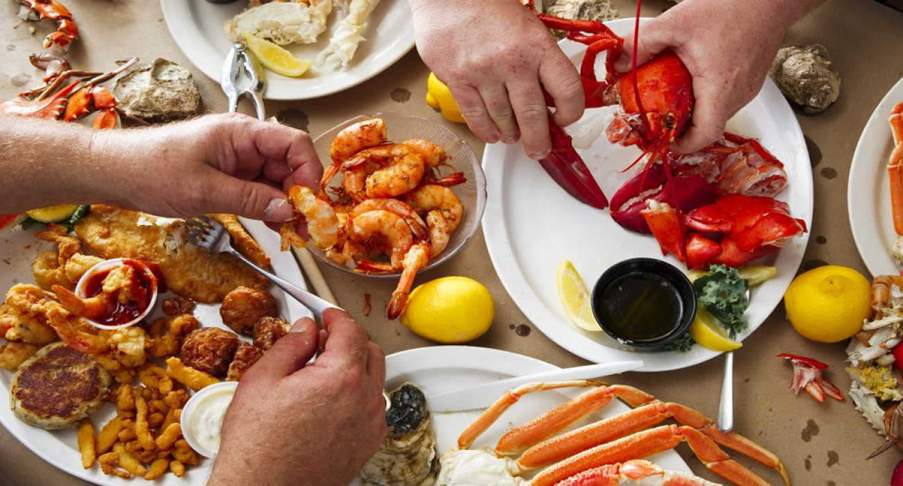 A group friends share a few platters at one of the best Clearwater seafood restaurants.